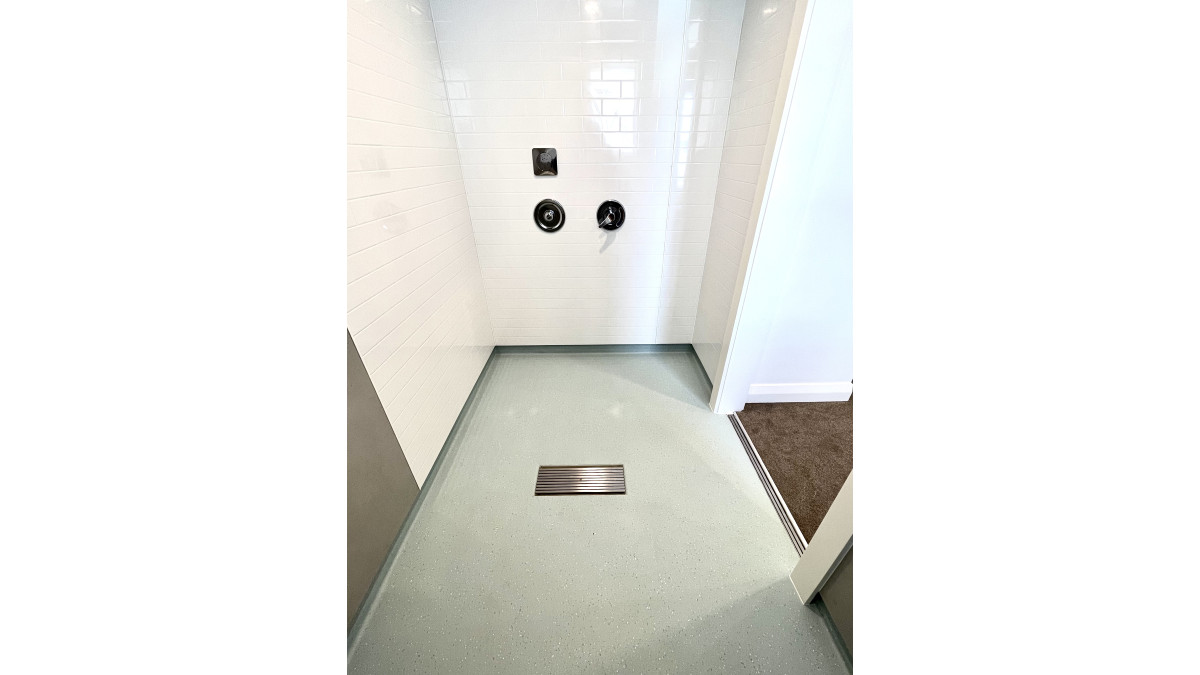 JESANI custom 450mm long vinyl clamp shower channel with security grille and a JESANI Door Channel. The door channel sitting at the threshold prevents flooding into the students bedroom and the floor cleaning products from staining the carpet. 