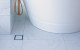 InvisiDrain tile insert drain grate next to bath floor overflow drain product slide