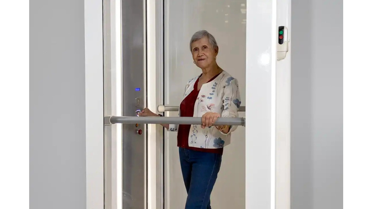 woman inside the Through floor lift Luma by Savaria