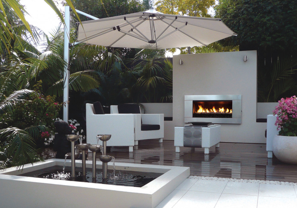 A Lush Palm-Fringed Courtyard with an Escea Fireplace