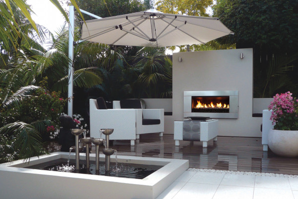 A Lush Palm-Fringed Courtyard with an Escea Fireplace
