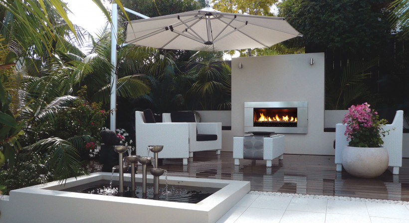 A Lush Palm-Fringed Courtyard with an Escea Fireplace