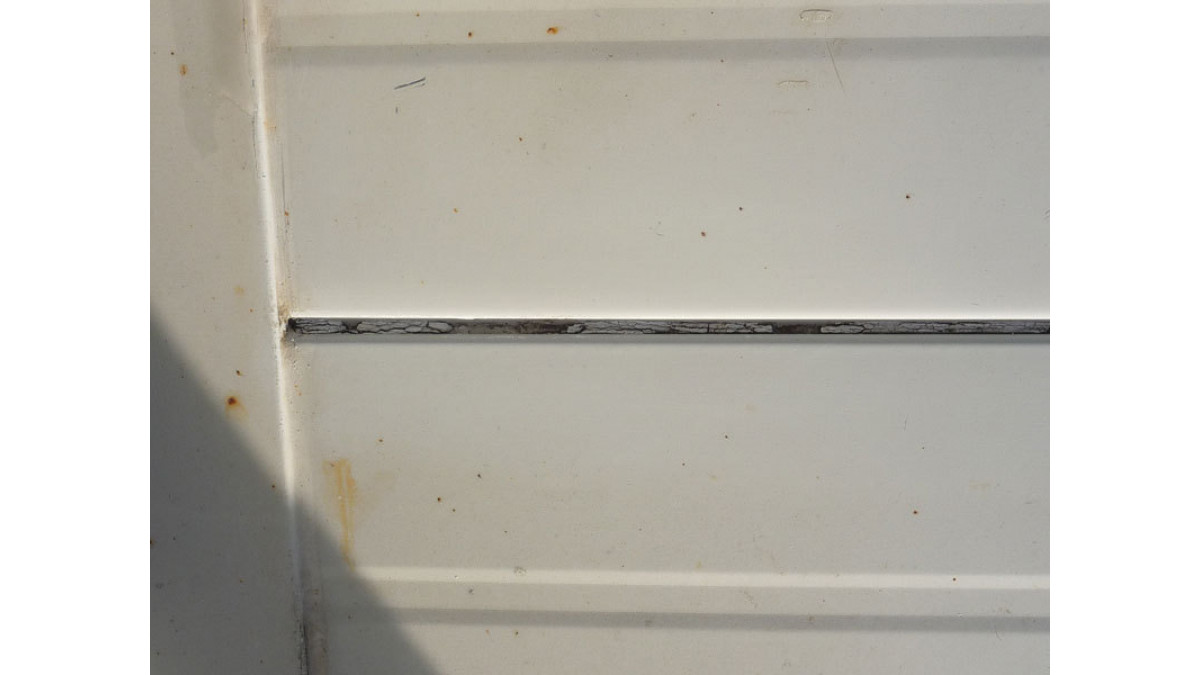 Join between sheets of roofing iron showing old sealant.