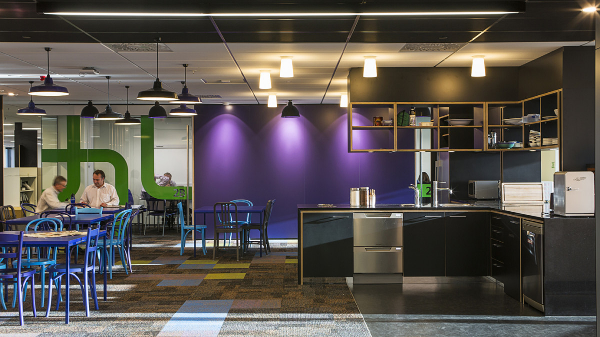 Each floor is given an identity through individual colour themes in this central space, using strong colours on walls to create a bold contrast to the dark kitchen and lobby area.
