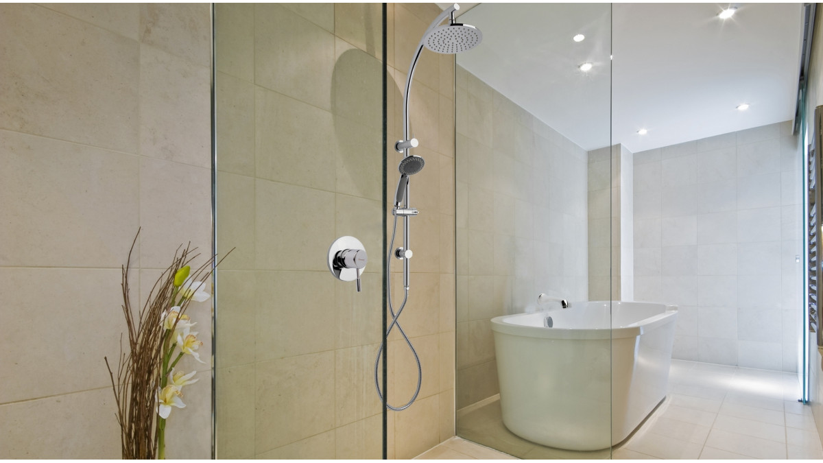 The large natural-coloured tiles of this bathroom add to the spa-like experience that this double-headed shower provides.