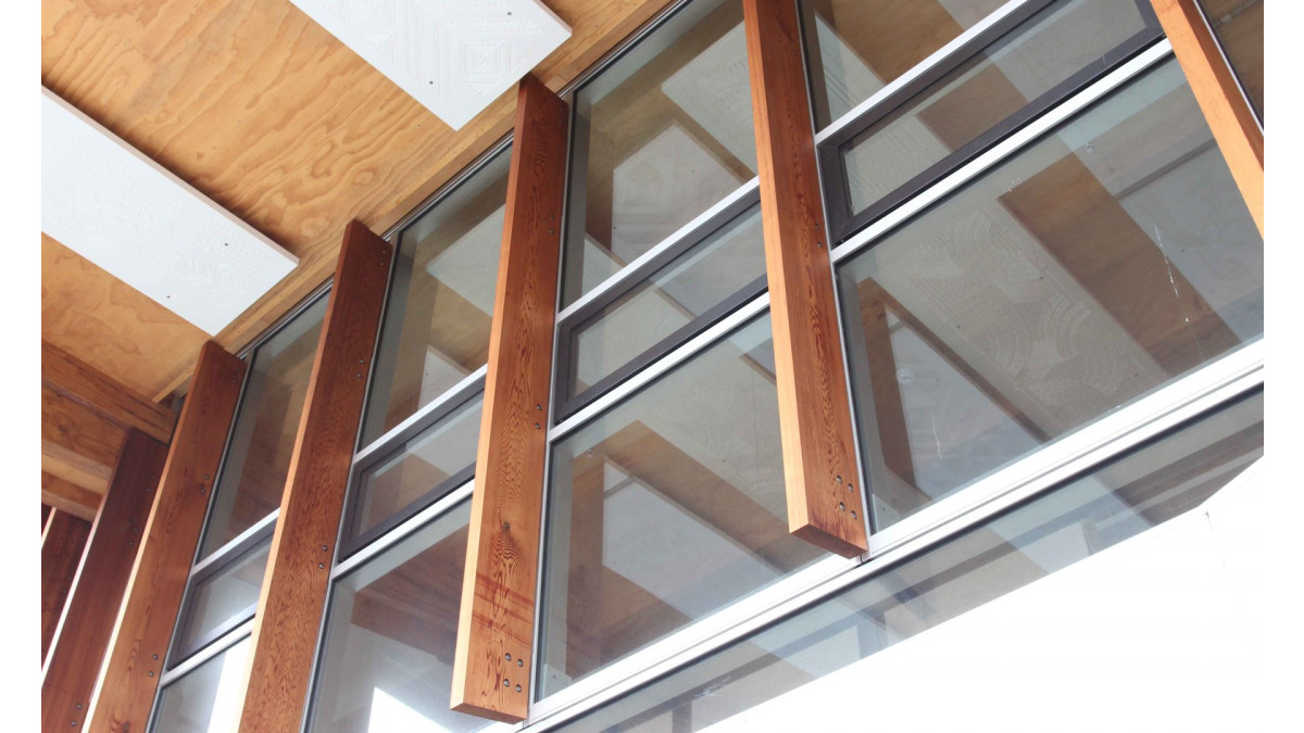 Large cedar vertical fins penetrate the Flushglaze mullions and are supported by steel beams and brackets in the interior.