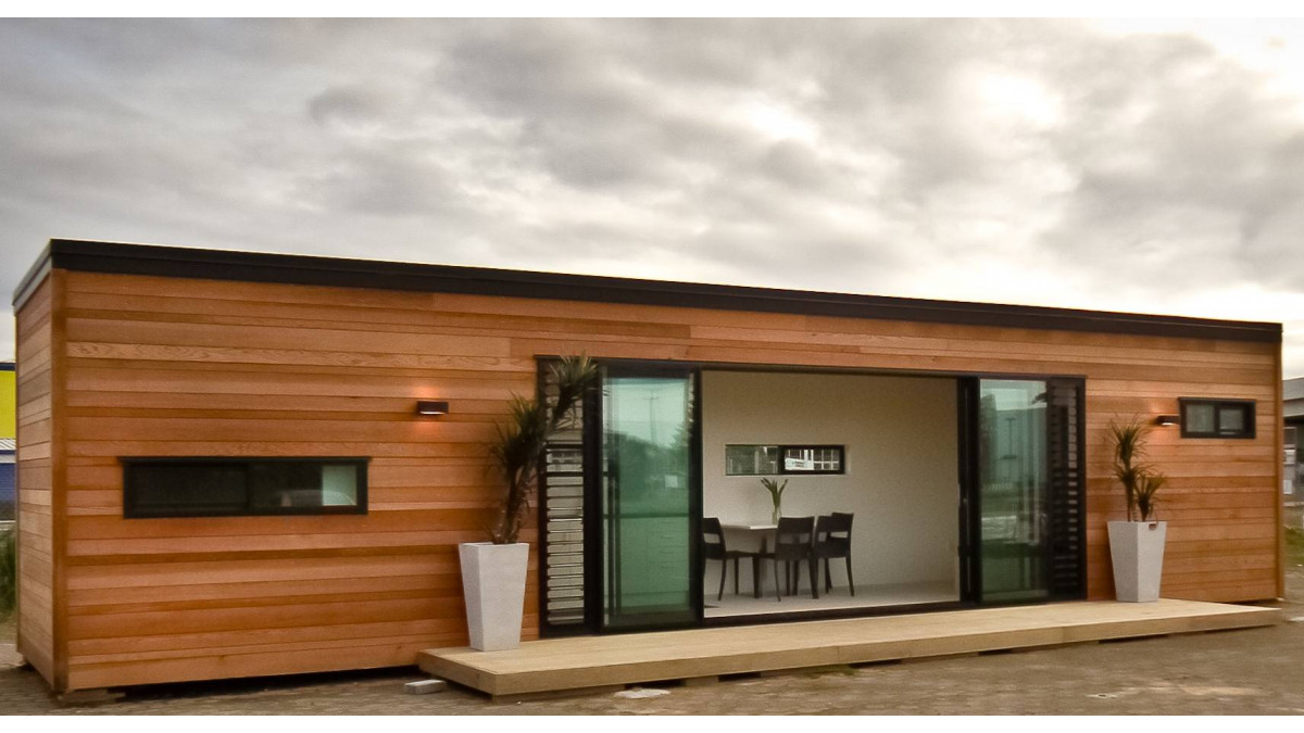 A container accommodation unit, by Cubular, clad in random width cedar boards with Matt Black powder coat Vantage windows and doors.