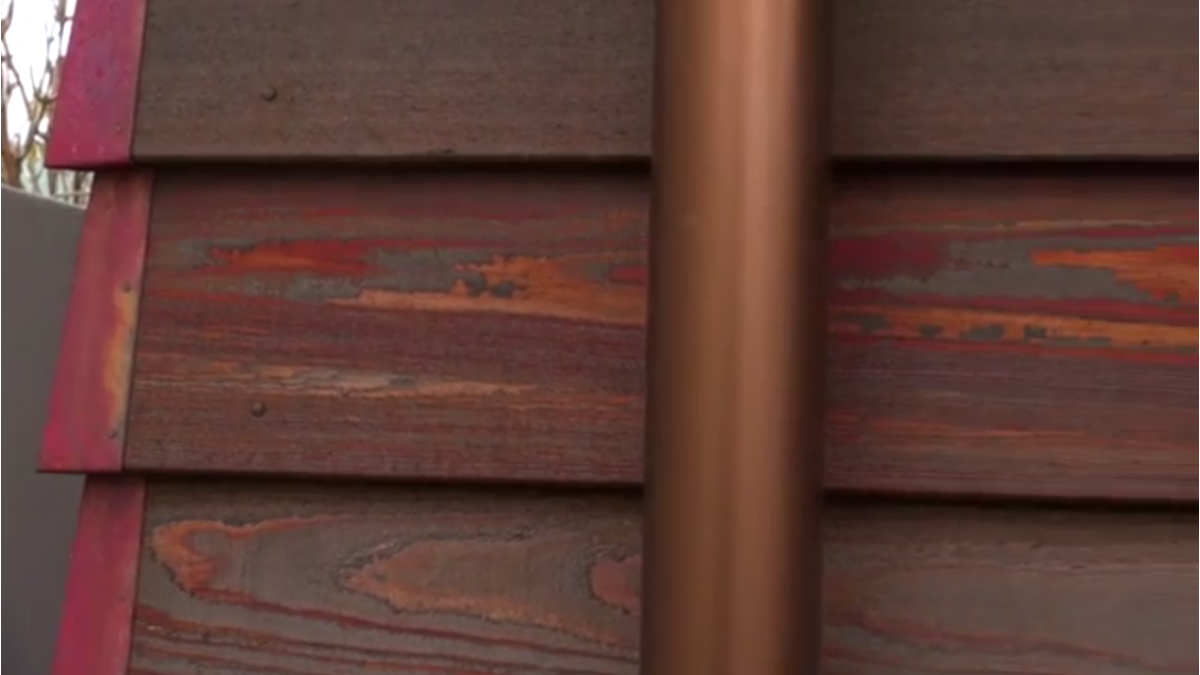 Close up of the downpipes against the copper exterior.