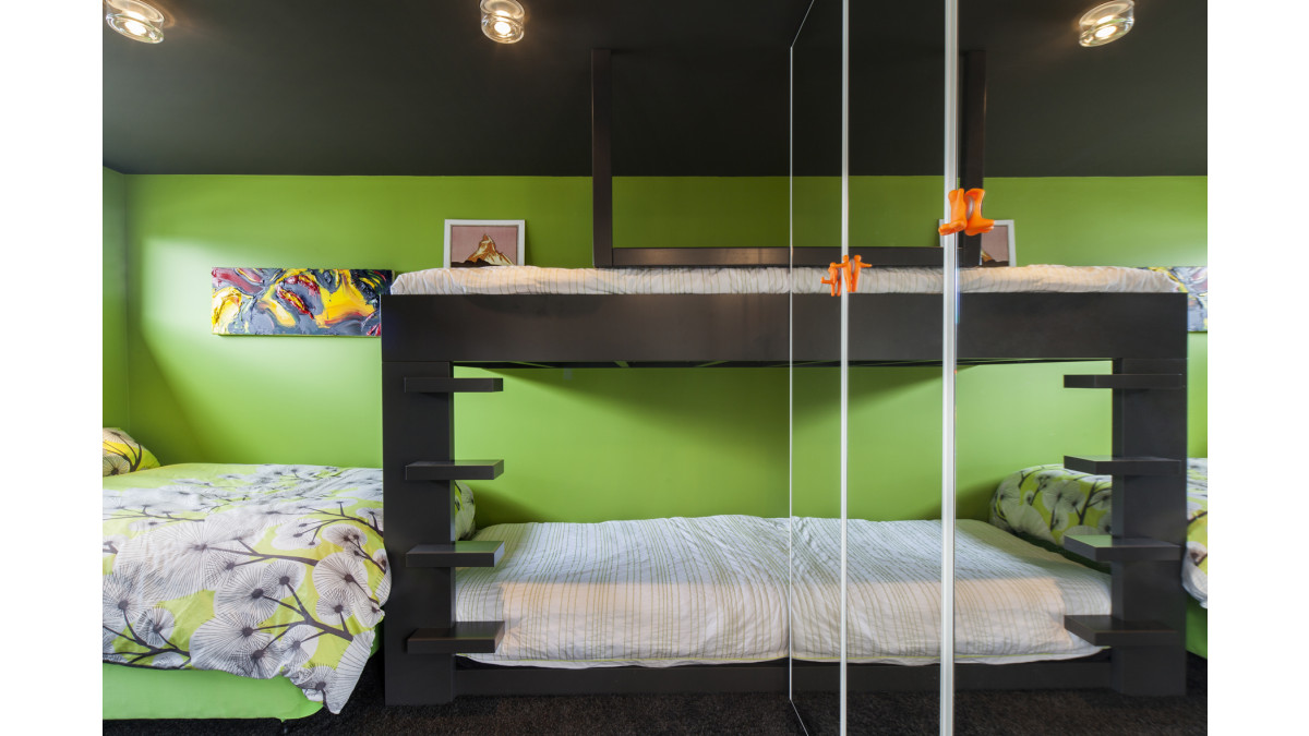 This bunk room is finished in fresh green Resene Sushi, with a Resene Ironsand ceiling, which gives the effect of being under the expansive night sky.