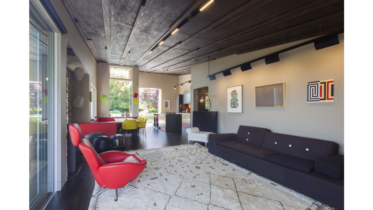 This dark wood stain finish of Resene Colorwood Dark Oak on the ceiling extends through the living and kitchen areas. The walls are kept deliberately neutral in Resene Craigieburn as a quiet counterpoint to the artwork.