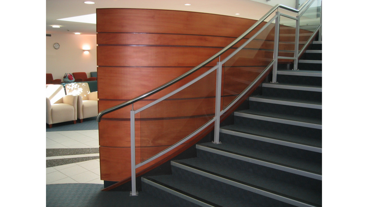 Custom curved framed glass balustrade with stainless steel handrail. 