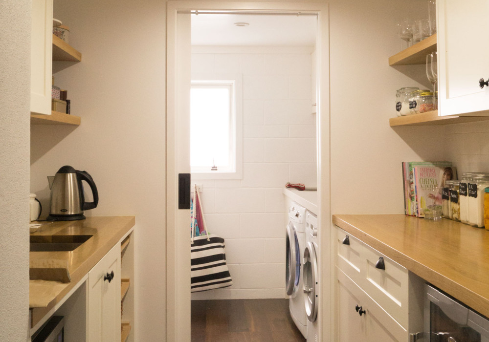Self-closing Cavity Slider Divides Kitchen and Laundry Spaces