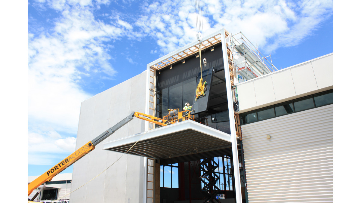 A structural glaze panel is lifted into place.