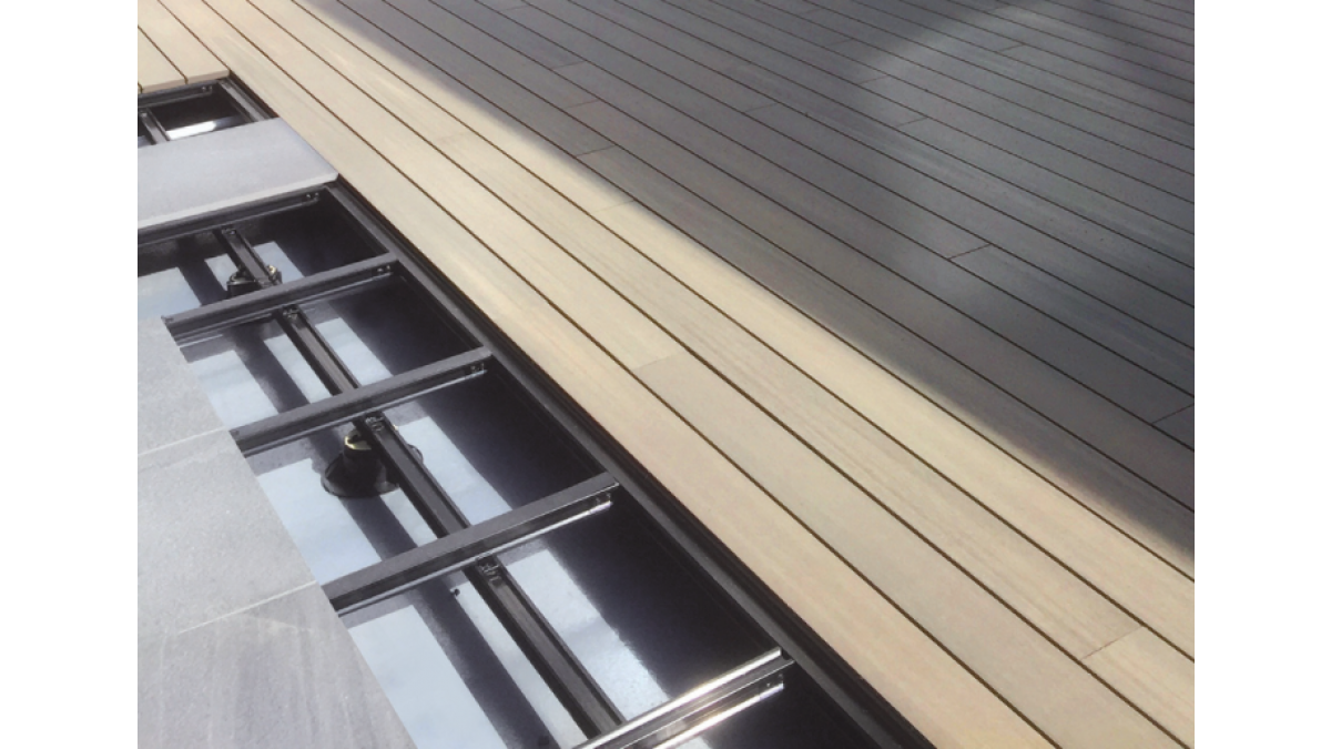 Close-up of ResortDeck and Outdure Tiles being installed on QwickBuild over membrane.