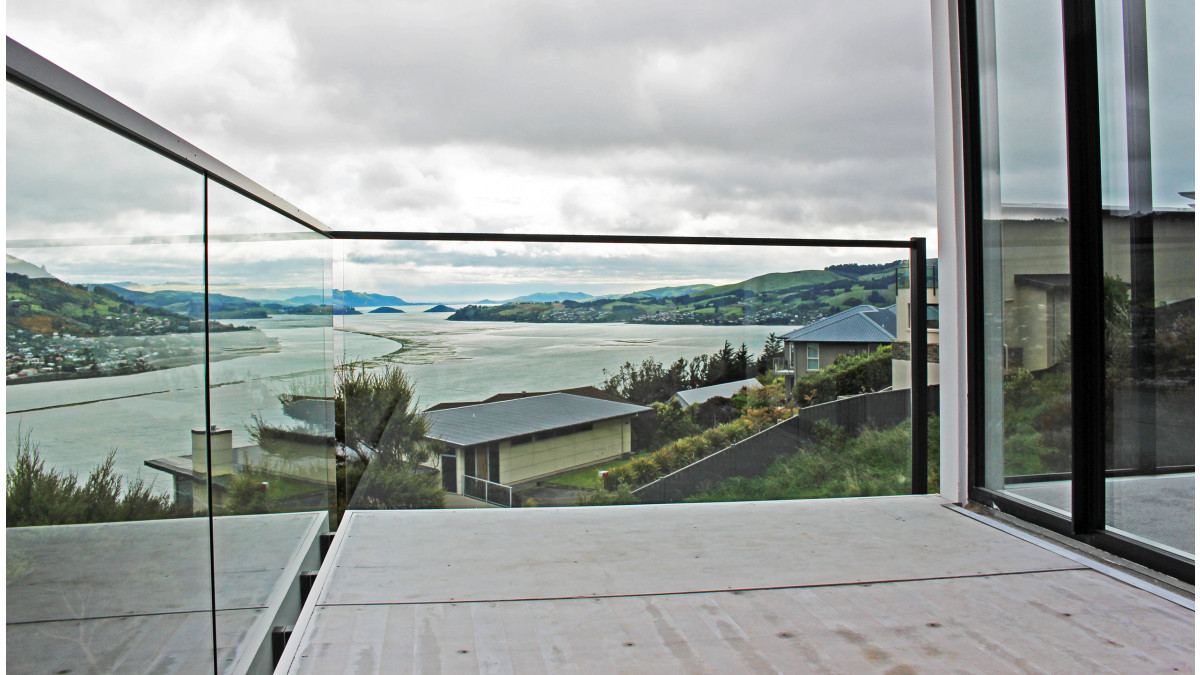 Edgetec JH Clamp Frameless Glass Balustrade with Interlinking Top Rail fixed to balustrade post.