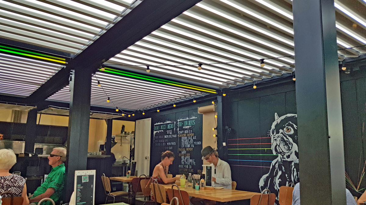 Bask Louvre Roofs sheltering the courtyard on a hot summers day at Moxi Cafe.