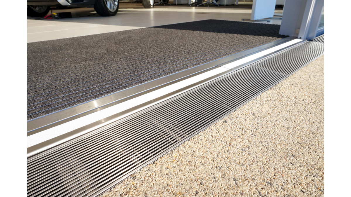 Level entry strip drain in car showroom doorway by Allproof.