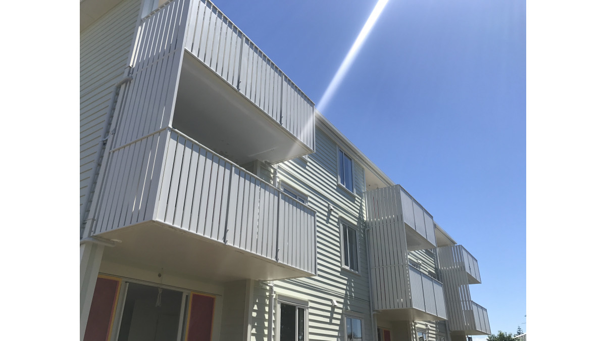 Vertical slat balustrade with privacy screens on a multi-unit development.