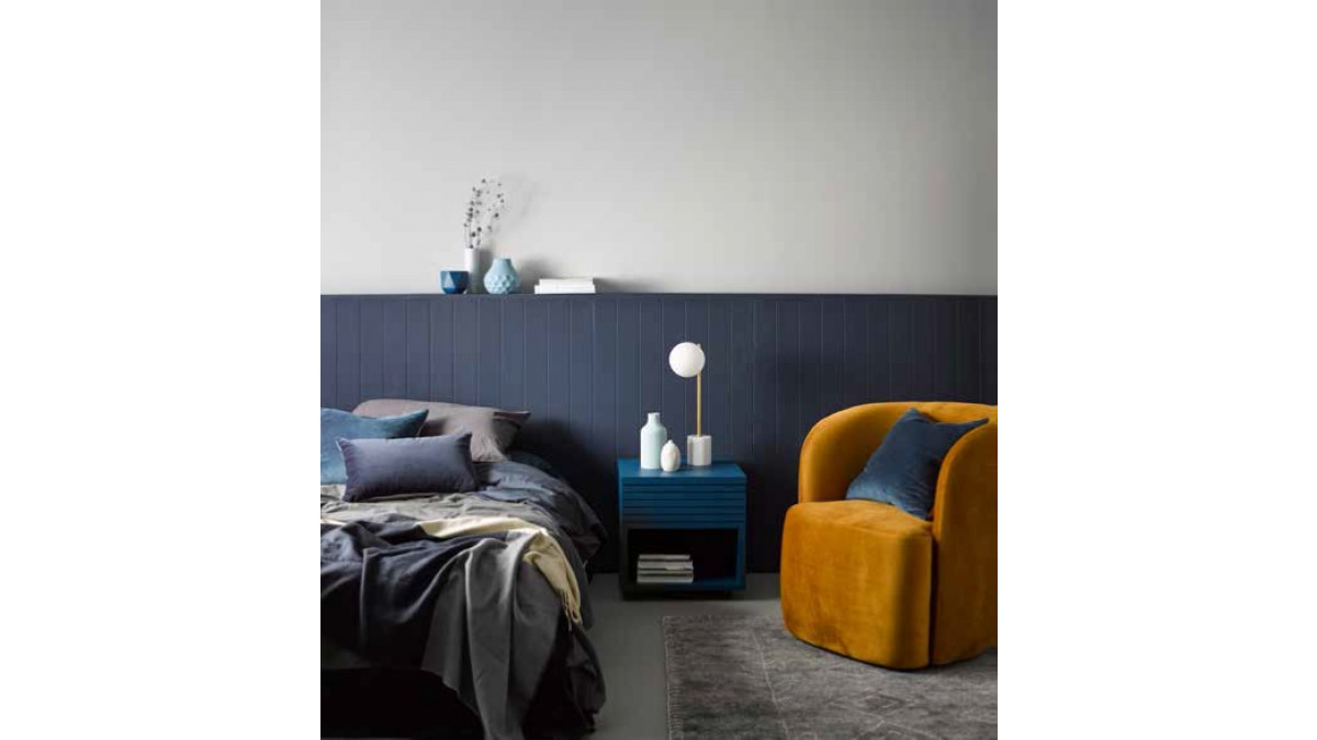 Cloudy greys and moody blues are layered sky high in this sophisticated master bedroom, while brass details and an ochre velvet chair provide a touch of warmth to balance out this otherwise cool space.