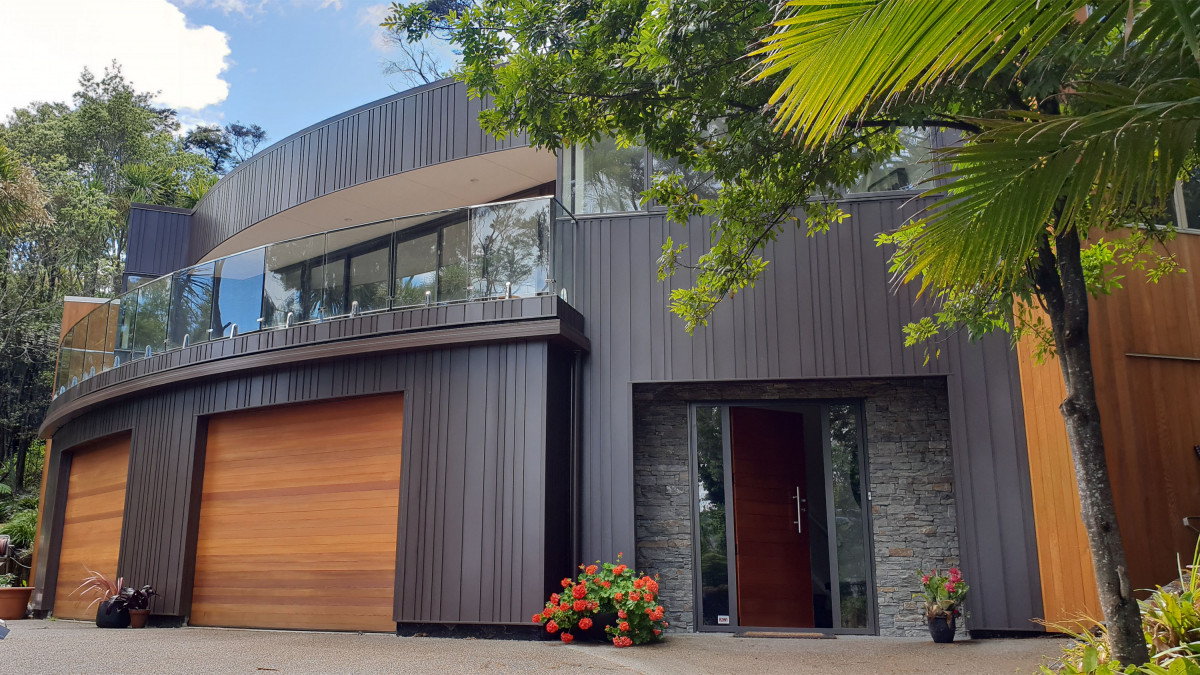 This home in West Auckland features random vertical cladding and curved walls. 