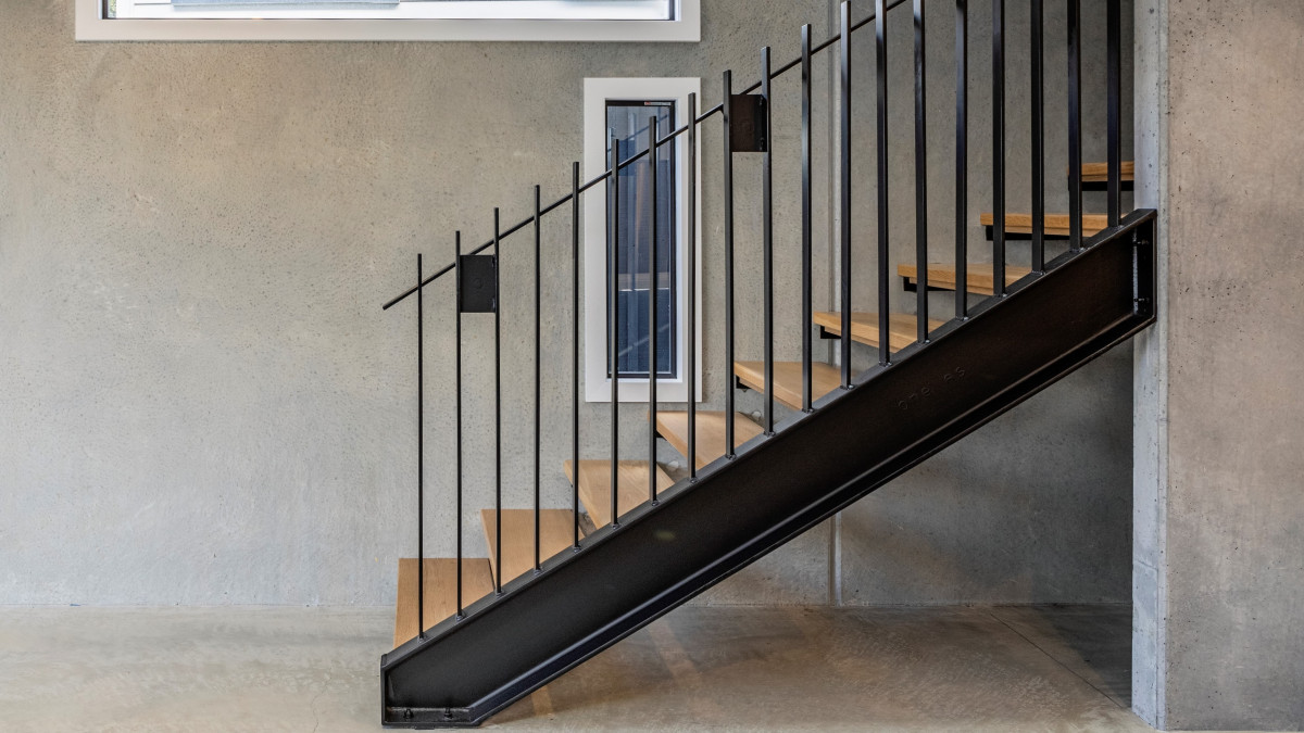 Litecrete walls and concrete floors with black staircase.