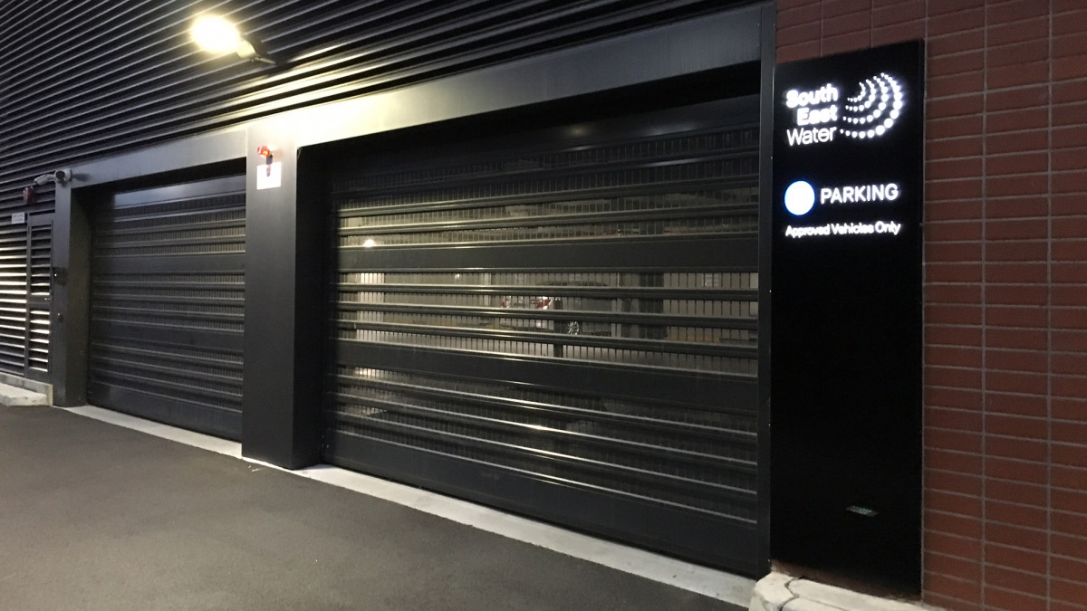 At the South East Water facility, laths powder coated in dark grey match the ventilation grille above while complementing adjacent brick veneer cladding.