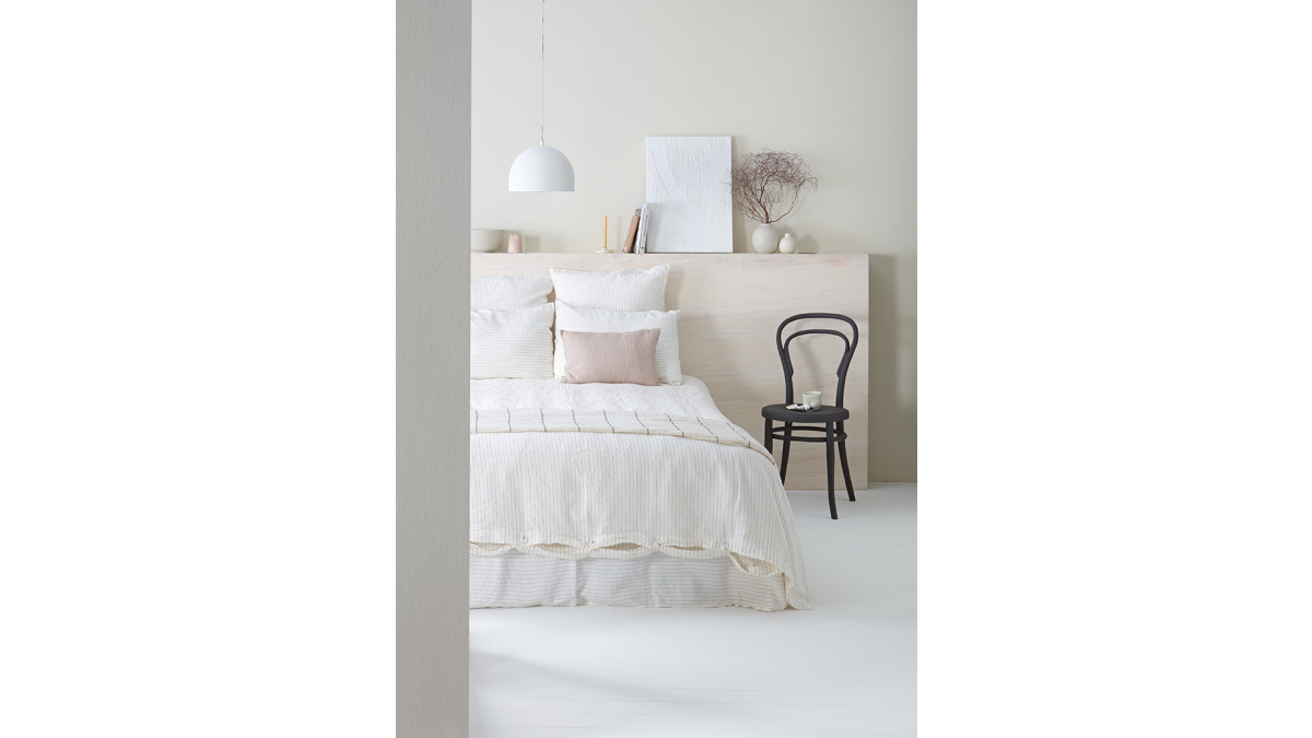 A timber headboard finished in Resene Colorwood Whitewash adds another layer of visual texture and variety to this airy tonal space. Wall in Resene Triple Pearl Lusta, floor and pendant lamp in Resene Eighth Pearl Lusta.