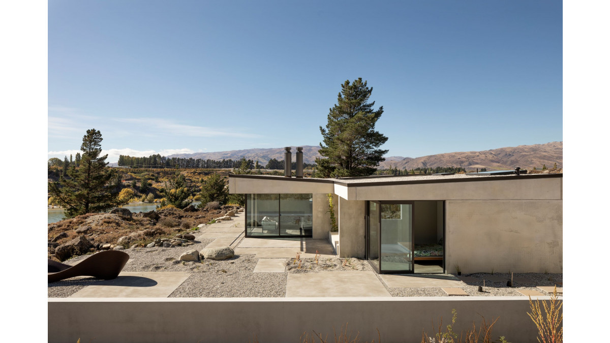 The home lies low on the site and is primarily constructed of precast concrete panels, hand-tinted to match the earth.