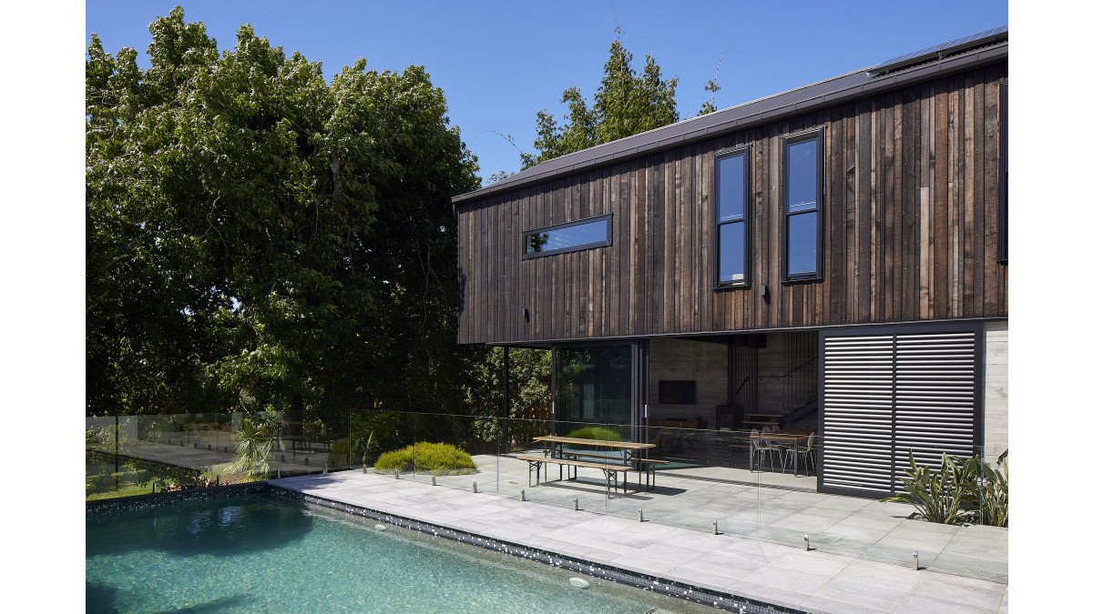 Windows and doors by Altherm in Matt Black recede against the dark cedar cladding.