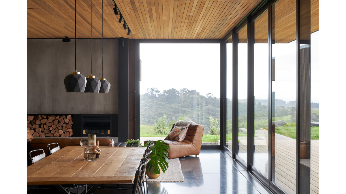 Modern living room with APL Architectural Series Sliding Doors and Custom Windows in Matt Black finish.