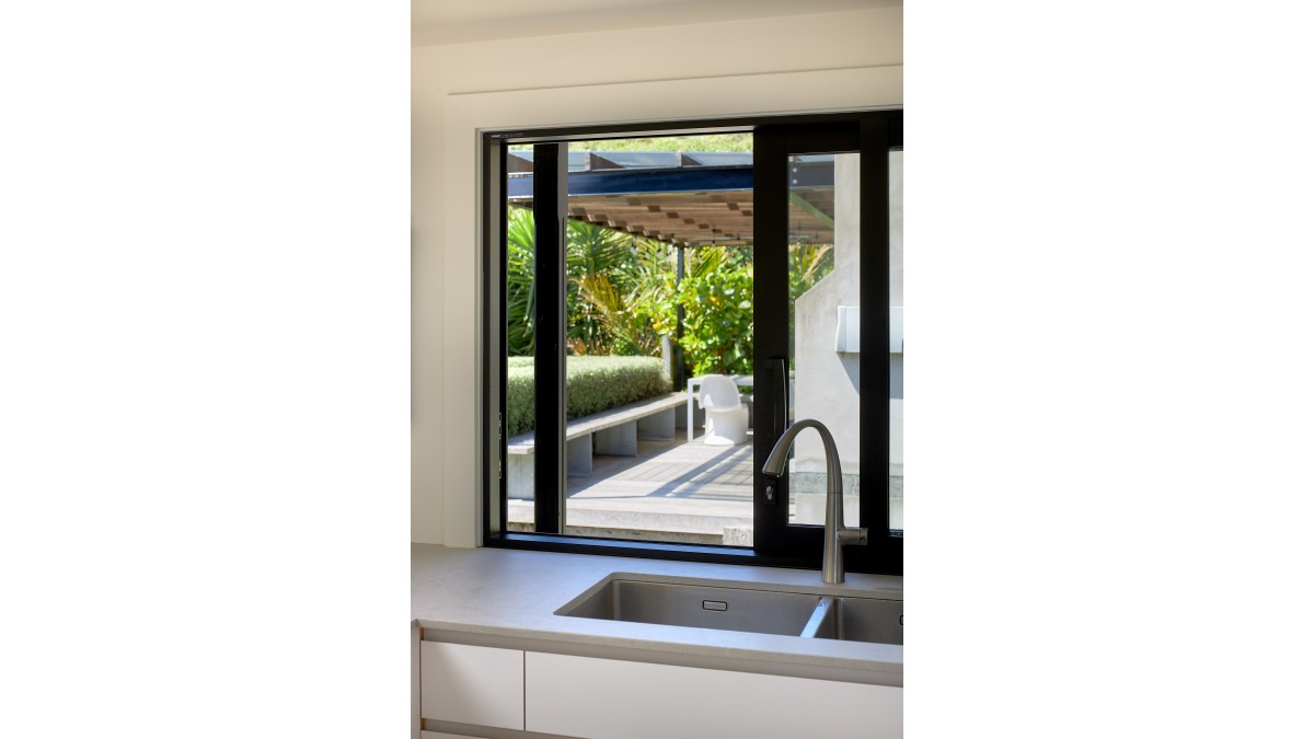 A kitchen sliding window allows for easy food transfer to outdoor living.