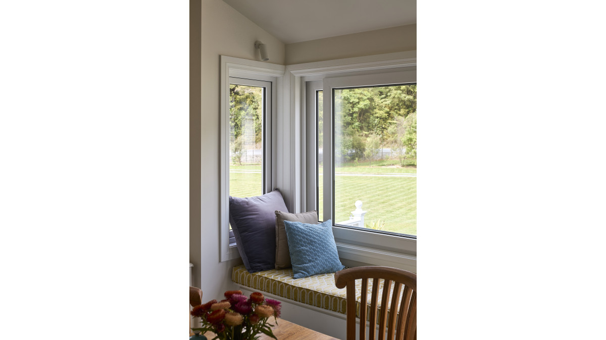 Klima sliding windows in a white profile match the home's original aesthetic.