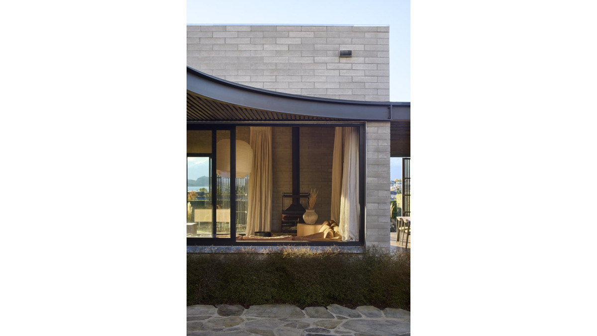 Exterior trims and the surround of the dark bronze anodised Metro Series sliding window link the living room to the courtyard.