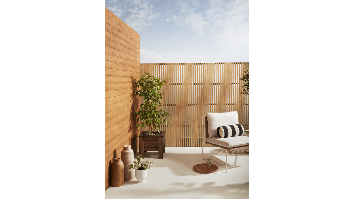 Timber weatherboards (left) finished in Resene Woodsman Cedar Natural Wood Oil Egmont, screen finished in Resene Woodsman Cedar Natural Wood Oil Aorangi, patio floor painted in Resene Walk-on tinted to Resene Merino.