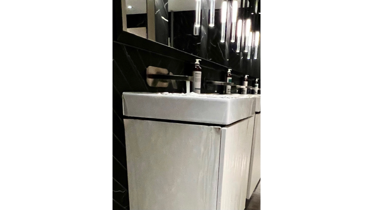 A running tap, a blocked P-trap, and a false sense of security. Despite having an overflow, this hotel basin flooded — the overflow connects above the blockage, so once the P-trap’s full, water has nowhere to go. Note the existing damage from this happening before.